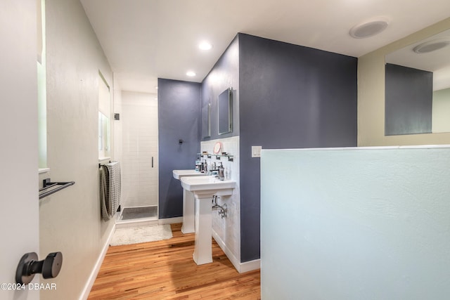 bathroom with tasteful backsplash, hardwood / wood-style flooring, and a shower with shower door