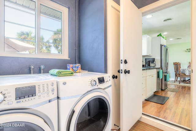 washroom with washer and clothes dryer, sink, and light hardwood / wood-style flooring