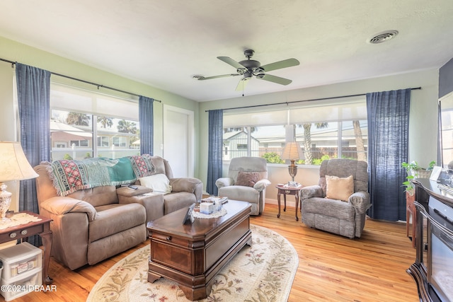 living room with ceiling fan, a healthy amount of sunlight, and light hardwood / wood-style flooring