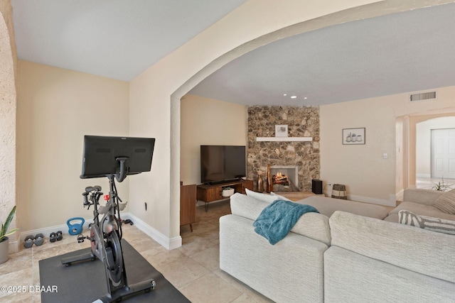 208 Pine Cone Trl, Ormond Beach, FL 32174 - exercise area featuring arched walkways, a stone fireplace, and baseboards