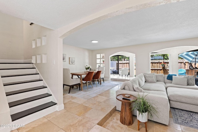 208 Pine Cone Trl, Ormond Beach, FL 32174 - living area featuring arched walkways, stairs, light tile patterned flooring, and a textured ceiling