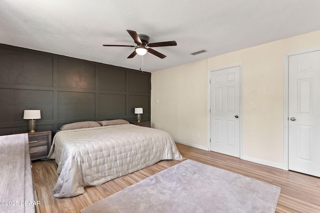 208 Pine Cone Trl, Ormond Beach, FL 32174 - bedroom featuring a decorative wall, wood finished floors, baseboards, and ceiling fan