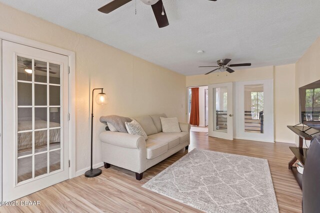 208 Pine Cone Trl, Ormond Beach, FL 32174 - living area with ceiling fan, wood finished floors, a textured ceiling, and baseboards