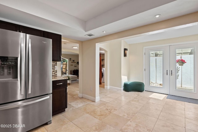 208 Pine Cone Trl, Ormond Beach, FL 32174 - kitchen featuring stainless steel refrigerator with ice dispenser, arched walkways, washer / clothes dryer, recessed lighting, and light stone countertops