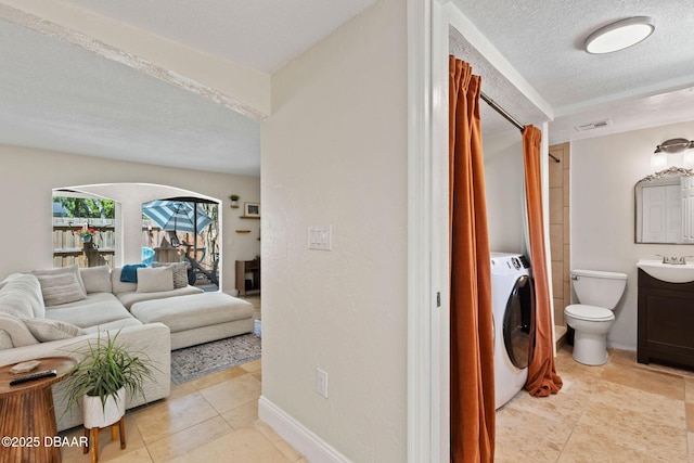 208 Pine Cone Trl, Ormond Beach, FL 32174 - full bathroom with washer / dryer, a textured ceiling, vanity, tile patterned floors, and toilet