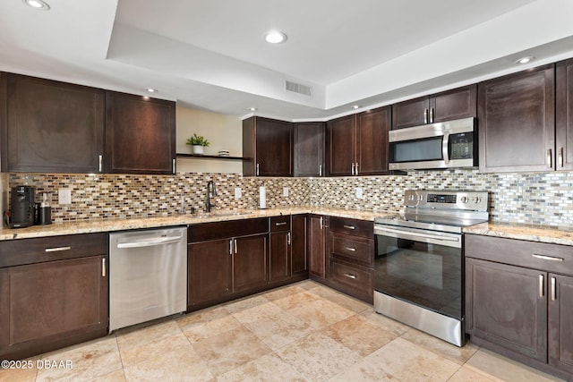 208 Pine Cone Trl, Ormond Beach, FL 32174 - kitchen featuring appliances with stainless steel finishes, open shelves, a sink, dark brown cabinets, and light stone counters