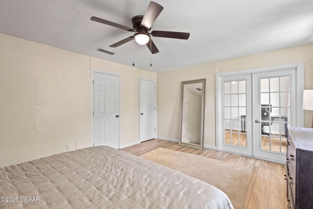 208 Pine Cone Trl, Ormond Beach, FL 32174 - bedroom featuring light wood-style flooring, a textured ceiling, french doors, a ceiling fan, and baseboards