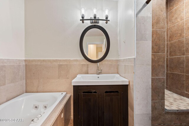 208 Pine Cone Trl, Ormond Beach, FL 32174 - full bathroom featuring a jetted tub, vanity, tile walls, and a wainscoted wall