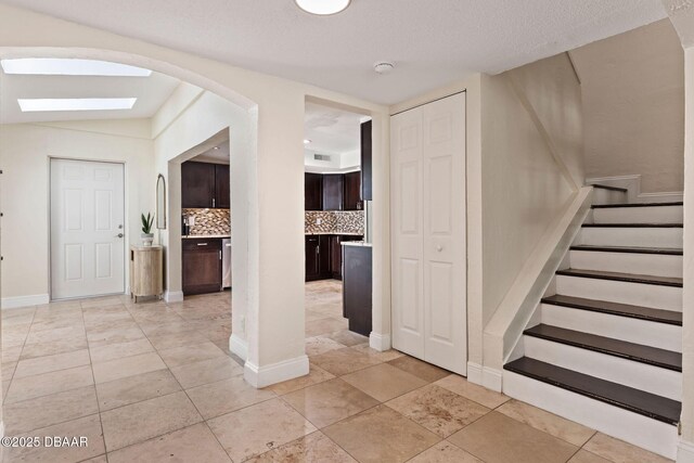 208 Pine Cone Trl, Ormond Beach, FL 32174 - entrance foyer with arched walkways, stairs, and baseboards