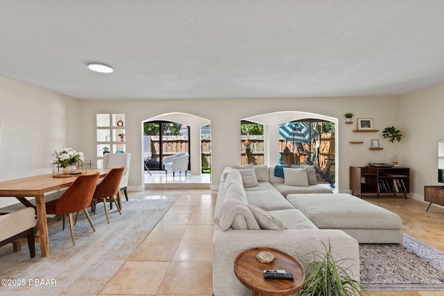 208 Pine Cone Trl, Ormond Beach, FL 32174 - living area featuring arched walkways, light tile patterned flooring, and a textured ceiling