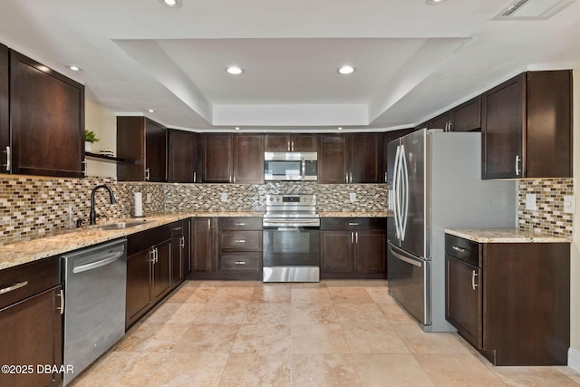 208 Pine Cone Trl, Ormond Beach, FL 32174 - kitchen with stainless steel appliances, a sink, a raised ceiling, light stone countertops, and recessed lighting