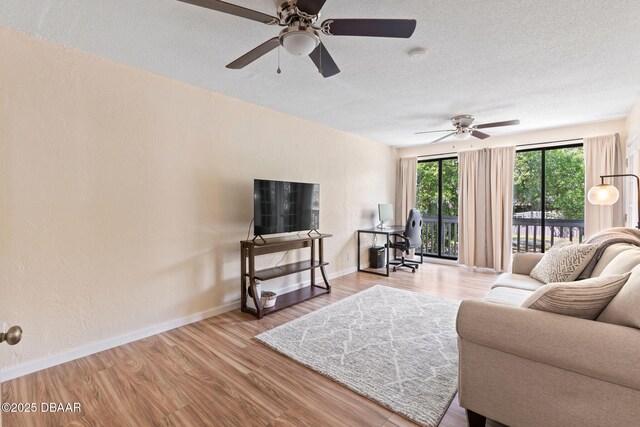 208 Pine Cone Trl, Ormond Beach, FL 32174 - living area featuring a ceiling fan, baseboards, wood finished floors, and a textured ceiling