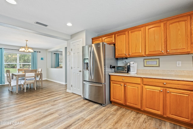 kitchen with stainless steel refrigerator with ice dispenser, light hardwood / wood-style flooring, a textured ceiling, decorative light fixtures, and a chandelier