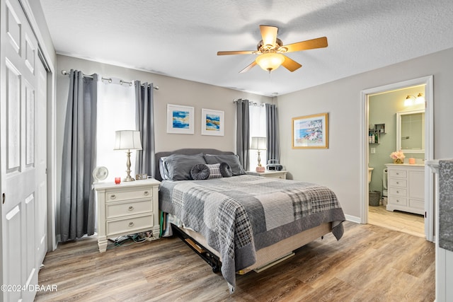 bedroom featuring a textured ceiling, light wood-type flooring, ensuite bathroom, and ceiling fan