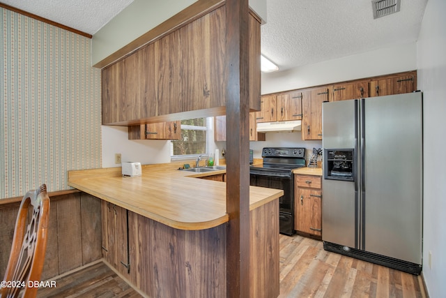 kitchen with sink, stainless steel refrigerator with ice dispenser, light hardwood / wood-style flooring, electric range, and a textured ceiling