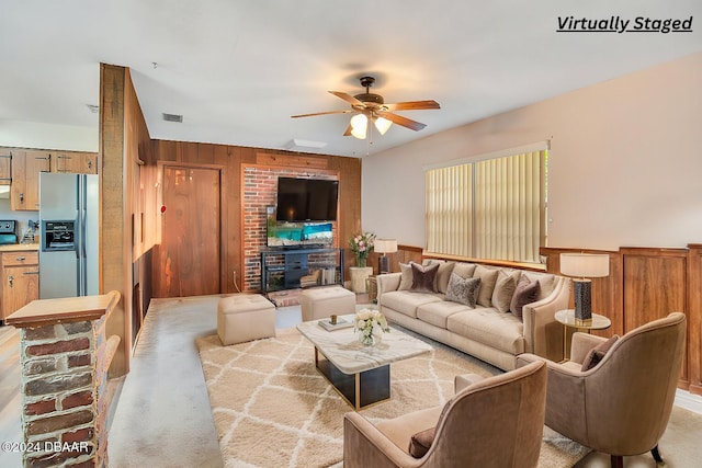 carpeted living room featuring ceiling fan and wood walls