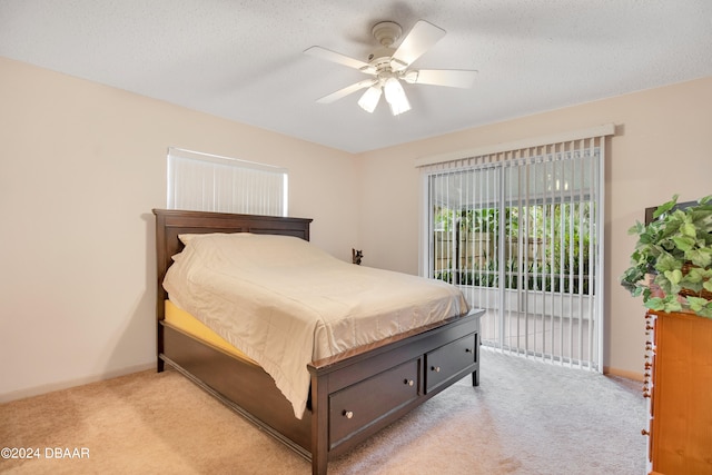 carpeted bedroom featuring access to exterior, a textured ceiling, and ceiling fan