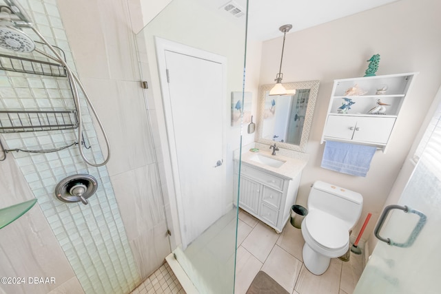 bathroom featuring walk in shower, vanity, tile patterned floors, and toilet