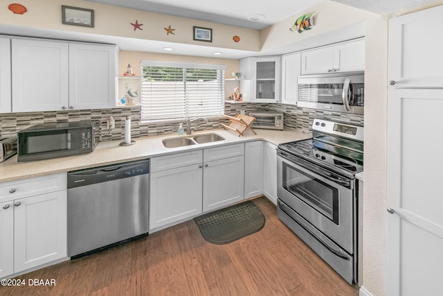 kitchen featuring tasteful backsplash, stainless steel appliances, sink, white cabinets, and dark wood-type flooring