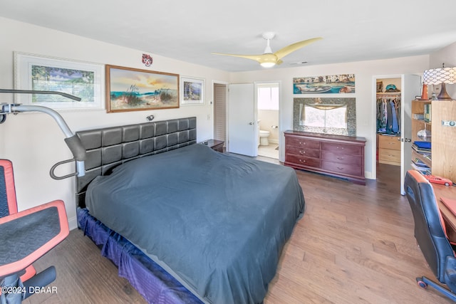 bedroom featuring a closet, a walk in closet, connected bathroom, hardwood / wood-style floors, and ceiling fan