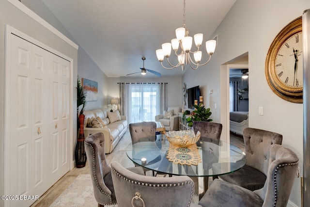 dining area featuring ceiling fan with notable chandelier and lofted ceiling