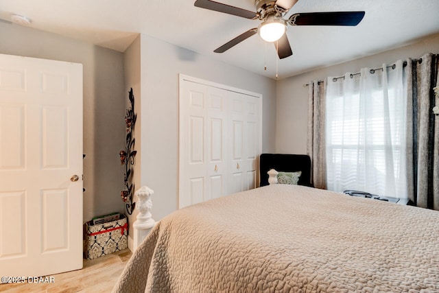 bedroom with ceiling fan, a closet, and light hardwood / wood-style flooring