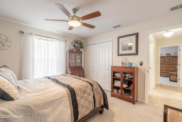 5452 Saint Regis Way, Port Orange, FL 32128 - bedroom with a closet, light carpet, ceiling fan, and a textured ceiling