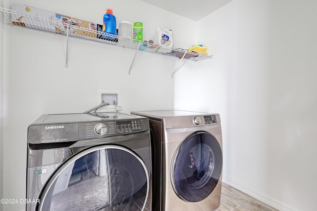 washroom with light wood-type flooring and independent washer and dryer