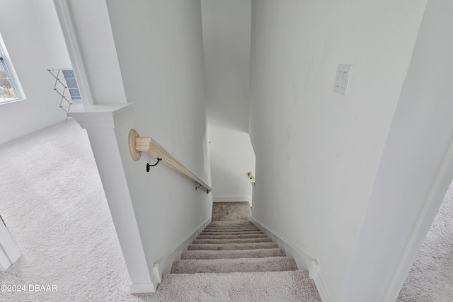 stairs with carpet floors and decorative columns