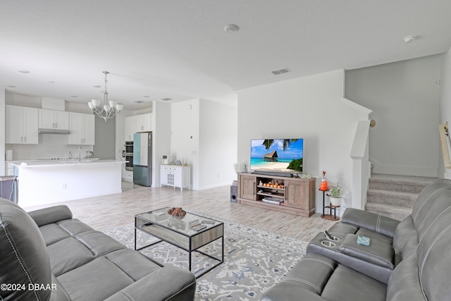 living room with light hardwood / wood-style flooring and a notable chandelier