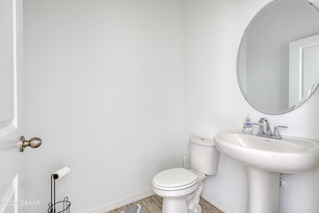 bathroom with hardwood / wood-style floors, toilet, and sink