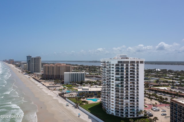 birds eye view of property with a water view and a beach view