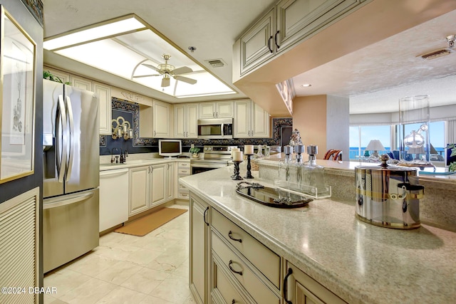 kitchen featuring decorative light fixtures, cream cabinets, ceiling fan, and stainless steel appliances