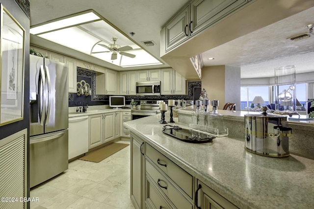 2425 S Atlantic Ave Unit 1403, Daytona Beach, FL 32118 - kitchen with stainless steel appliances, ceiling fan, light marble finish floors, cream cabinetry, and a sink
