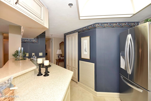 kitchen featuring stainless steel refrigerator with ice dispenser and light tile patterned flooring