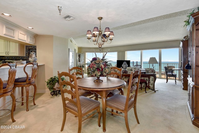 dining space featuring a textured ceiling, light carpet, and an inviting chandelier