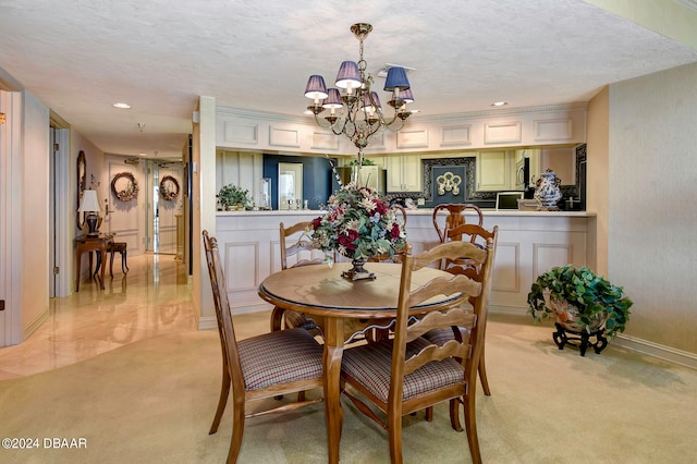 dining area with light carpet, a textured ceiling, and an inviting chandelier