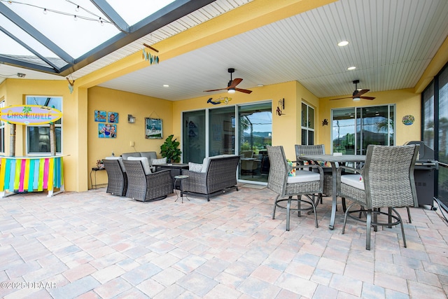 view of patio featuring outdoor lounge area, ceiling fan, and a lanai