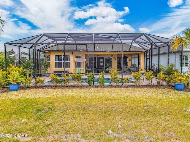 rear view of property with a lanai, a lawn, and a patio