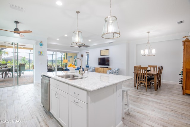 kitchen with ceiling fan, a kitchen island with sink, sink, dishwasher, and white cabinetry