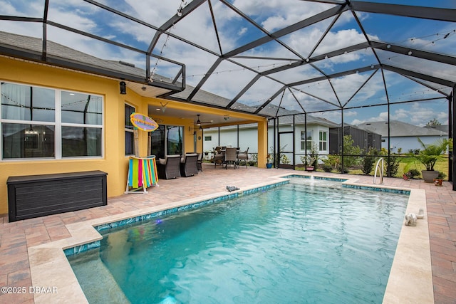 view of swimming pool featuring ceiling fan, a lanai, and a patio