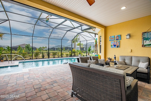 view of pool with pool water feature, an outdoor living space, a lanai, and a patio