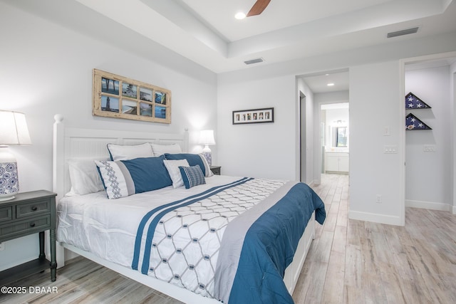 bedroom with hardwood / wood-style floors, connected bathroom, and ceiling fan