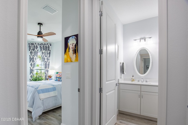 bathroom with hardwood / wood-style flooring, ceiling fan, and vanity