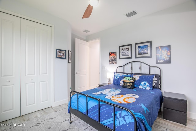 bedroom with light hardwood / wood-style floors, a closet, and ceiling fan