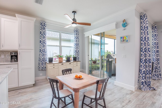 dining area with ceiling fan, crown molding, and light hardwood / wood-style floors