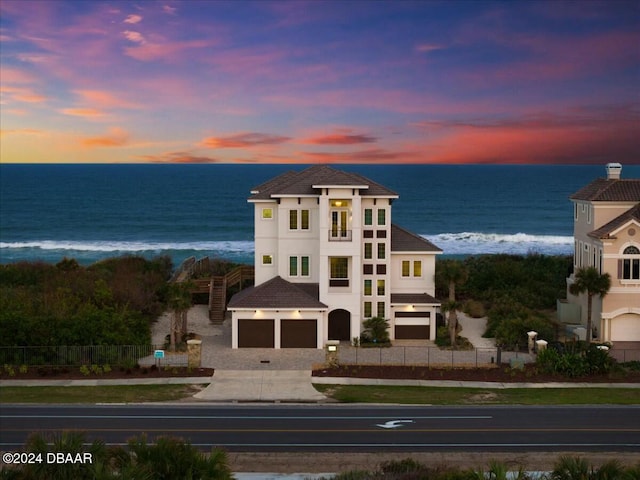 view of front of property with a garage and a water view