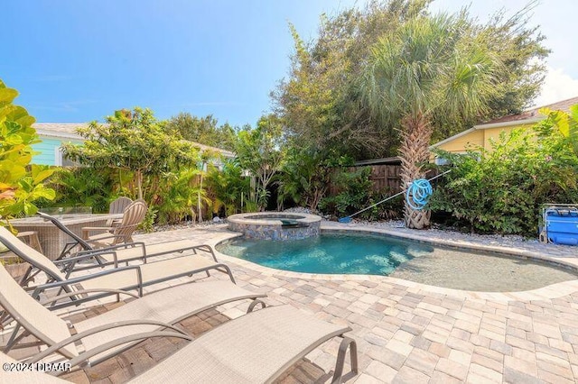 view of swimming pool featuring an in ground hot tub and a patio area