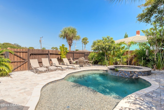 view of pool with a patio area and an in ground hot tub