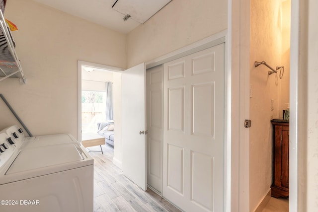 laundry area with washing machine and dryer and light hardwood / wood-style flooring